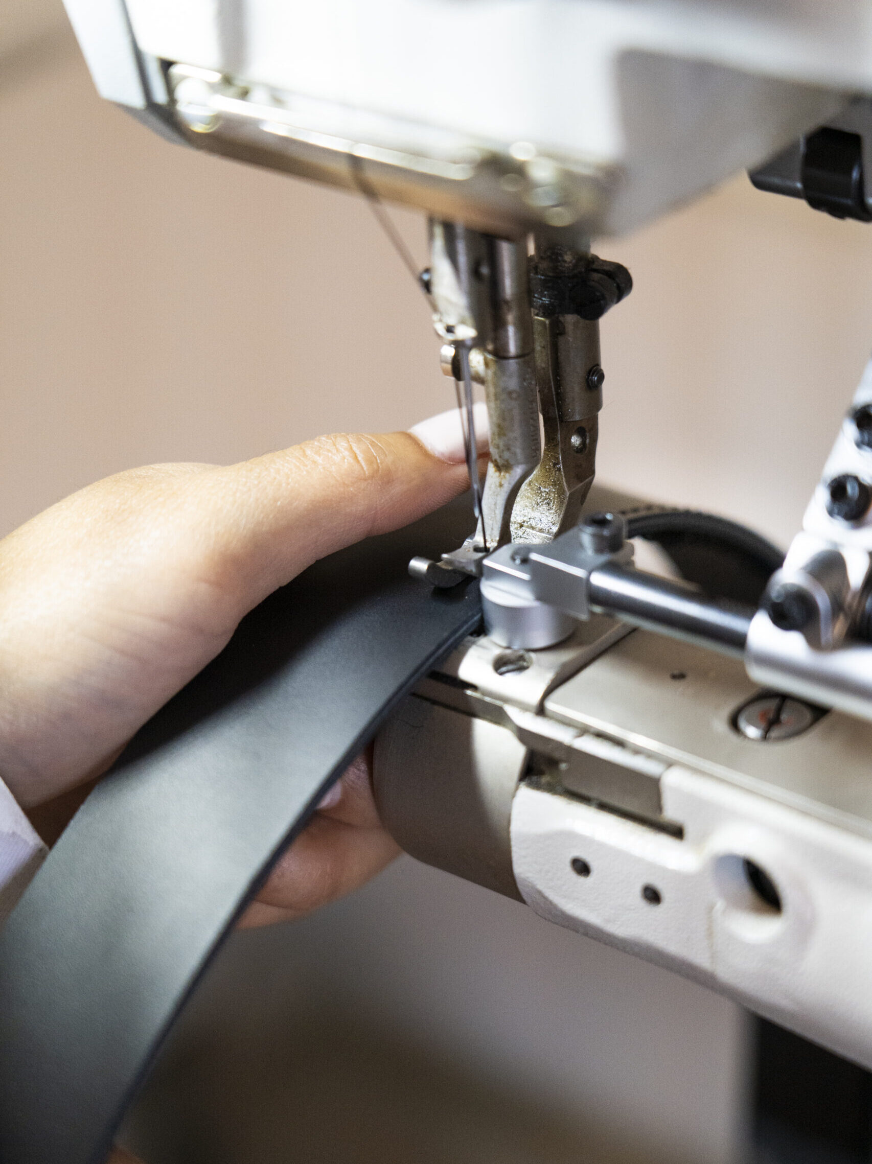My Hong Ho stikt een zwarte riem met een naaimachine